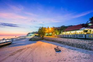 a view of a beach at sunset with a building at Kastapar Bridge Lembongan in Nusa Lembongan