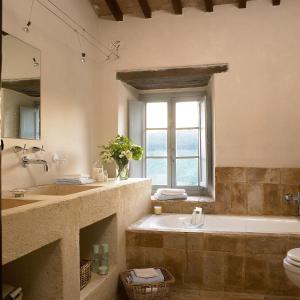 a bathroom with a tub and a toilet and a window at Borgo di Pianciano in Spoleto