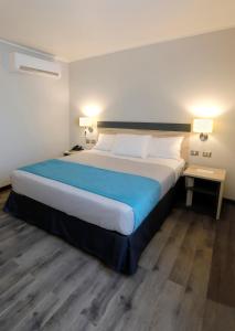 a large bed in a hotel room with two tables at Hotel Diego de Almagro Viña del Mar in Viña del Mar