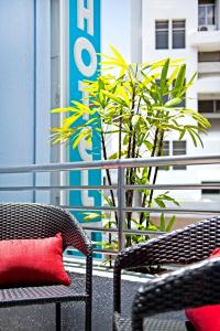 un patio con 2 sedie e un cuscino rosso di Hotel 81 Elegance a Singapore
