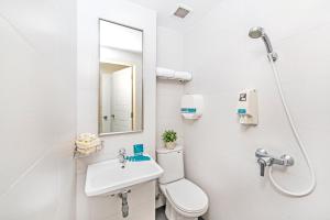 uma casa de banho com um WC, um lavatório e um espelho. em Hotel 81 Elegance em Singapura