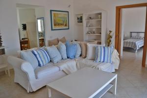 een woonkamer met een witte bank en blauwe kussens bij Maridea - Villa Mariella in Ponza