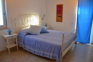 een slaapkamer met een bed met een blauw dekbed bij Maridea - Villa Mariella in Ponza