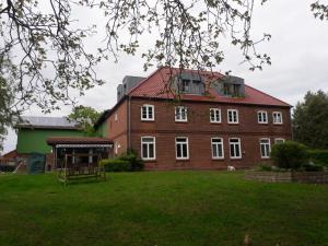 um grande edifício de tijolos vermelhos com um grande quintal em Bramaublick em Hitzhusen