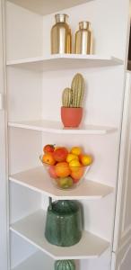 a white refrigerator with a bowl of fruits and vegetables at Vakantiehuis Katwijk in Katwijk
