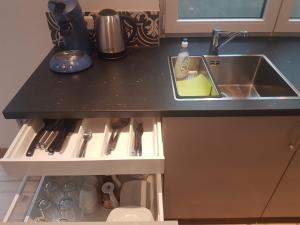 a kitchen counter with a sink and utensils at FeWo bei Alex in Ettenheim