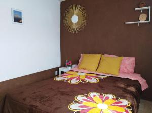 um quarto com uma cama com almofadas coloridas e um espelho em Casita Típica Cholulteca - Completa (8 prs) em Cholula