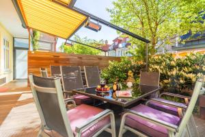 un patio con mesa, sillas y una valla en neyland apartments Norderney, en Norderney
