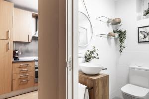 łazienka z umywalką, toaletą i lustrem w obiekcie The Estafeta View Apartment w Pampelunie