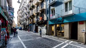 an empty city street with people walking down the street at The Estafeta View Apartment in Pamplona