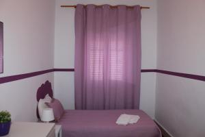 リスボンにあるリスボン サンシャイン ホームズの紫色のカーテンとベッドが備わるベッドルーム1室