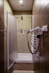 a shower in a bathroom with a phone on the wall at Boutique Hostel in Łódź
