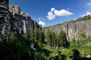 uma grande montanha rochosa com árvores em frente em Hotel Střelnice em Teplice nad Metují