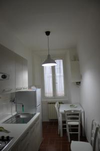 cocina con mesa y nevera blanca en Casa Naldi 2, en Florencia