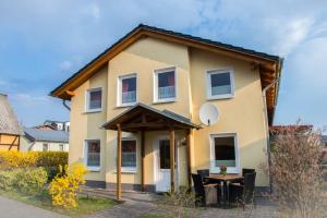 une maison jaune avec une table devant elle dans l'établissement Ostseeperle Usedom, à Heringsdorf