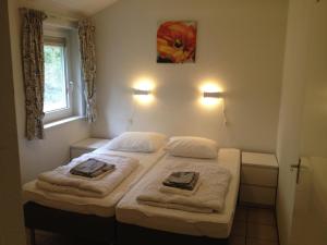 - une chambre avec 2 lits et des serviettes dans l'établissement Vakantiehuis Lochem, à Lochem
