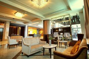 eine große Lobby mit Sofas, Stühlen und Tischen in der Unterkunft Intimate Hotel Pattaya - SHA Extra Plus in Pattaya
