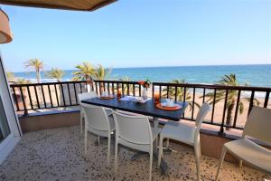 balcón con mesa, sillas y vistas al océano en Villaservice - Leonor, en Calafell