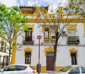 a yellow and white building with cars parked in front of it at Miraflores 58 Apt - Private Parking Opt in Seville