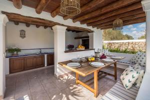 cocina y comedor con mesa de madera en Villa Can Fita, en Puig D’en Valls