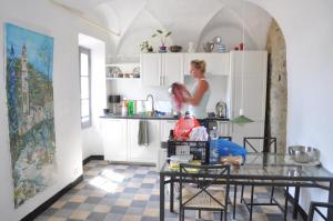 a woman standing in a kitchen with a table at Old Oilmill near Dolcedo in Dolcedo