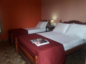 two beds in a hotel room with a magazine on the bed at Alto Del Valle Cafayate in Cafayate