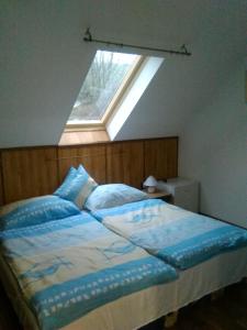 1 dormitorio con 1 cama y ventana en Cseppkő Panzió, en Abaliget