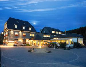 un gran edificio con patio por la noche en Landhaus Wacker, en Wenden