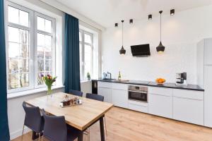 a kitchen and dining room with a wooden table and chairs at Old Town Super Apartment Ogarna in Gdańsk