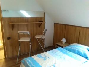 1 dormitorio con cama, escritorio y silla en Cseppkő Panzió, en Abaliget