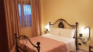 una camera da letto con un letto con lenzuola bianche e una finestra di Le Tre Rose a Bono