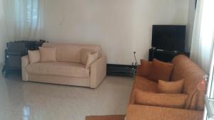 a living room with two couches and a flat screen tv at Katerina's House in Nea Makri