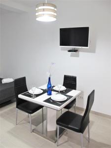 a dining room table with black chairs and a tv at SeaEye Trogir in Trogir