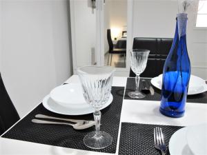 a blue bottle sitting on a table with plates and glasses at SeaEye Trogir in Trogir