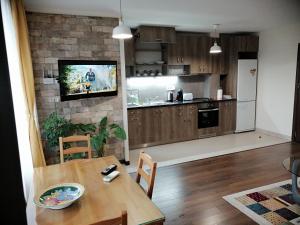 a kitchen with a table and a television on a brick wall at Apartments Sofia Yavorov in Sofia