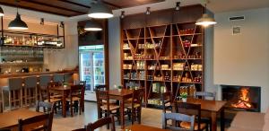 a restaurant with wooden tables and chairs and a fireplace at Platanos Rooms in Anopoli Sfakion