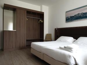 a bedroom with a large bed and a sliding door at Albergo Delle Alpi in Belluno