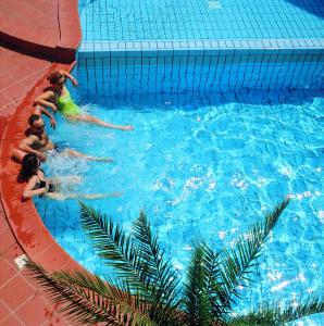 a group of people swimming in a swimming pool at Hotel Calypso in Cesenatico