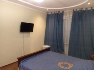 a bedroom with a bed and a flat screen tv at Квартира в Тирасполе in Tiraspol