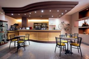 ein Restaurant mit Tischen und Stühlen und eine Bar in der Unterkunft River Park Hotel in Ameglia