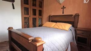 um quarto com uma cama de madeira e uma cruz na parede em Apartamento Acogedor en el Retiro em El Retiro