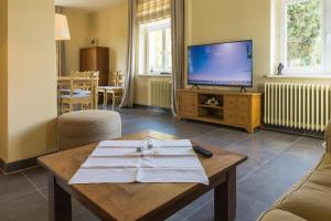 a living room with a table and a tv at Forsthaus Edelburg Ferienhaus in Hemer