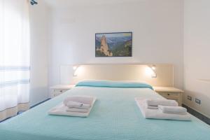 a bedroom with a bed with two towels on it at Biriola EcoResort Cala Gonone in Cala Gonone
