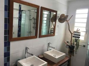 een badkamer met 2 wastafels en 2 spiegels bij LOCBIR in Le Diamant