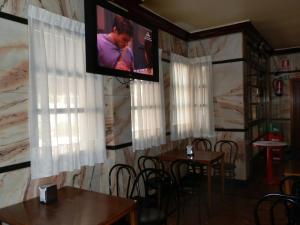 comedor con mesas y TV en la pared en Hostal Restaurante San Poul, en Consuegra