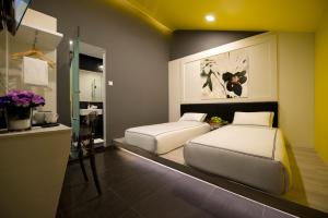 a bedroom with two beds and a counter with flowers at Venue Hotel in Singapore