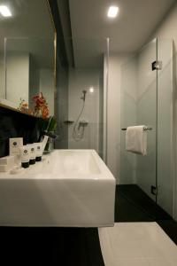 y baño con lavabo blanco grande y ducha. en Venue Hotel en Singapur