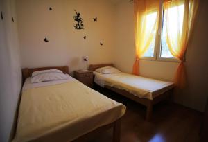 2 camas individuais num quarto com uma janela em Apartmani Marino em Vinišće