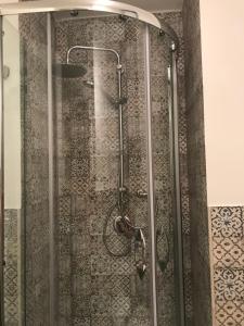 une douche avec une porte vitrée dans une salle de bain dans l'établissement La dimora dell’Artista, à Palerme