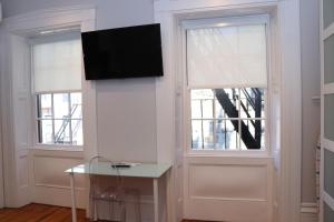 Habitación con 2 ventanas y TV en la pared. en Downtown Beacon Hill, Convenient, Comfy Studio #10, en Boston